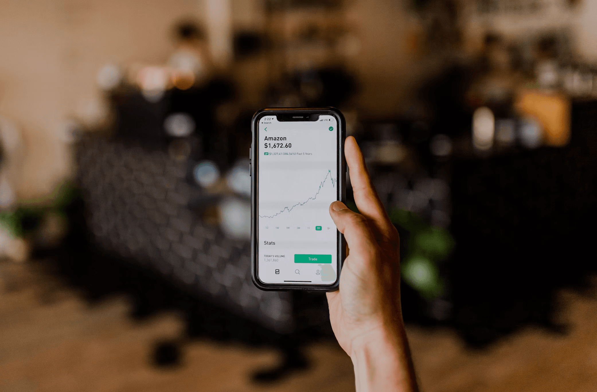A hand holding a phone showing an analytics dashboard