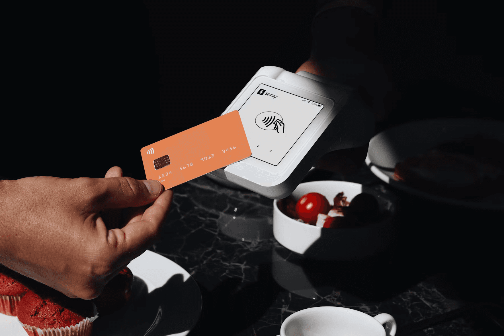 A hand paying with a card at a card reader